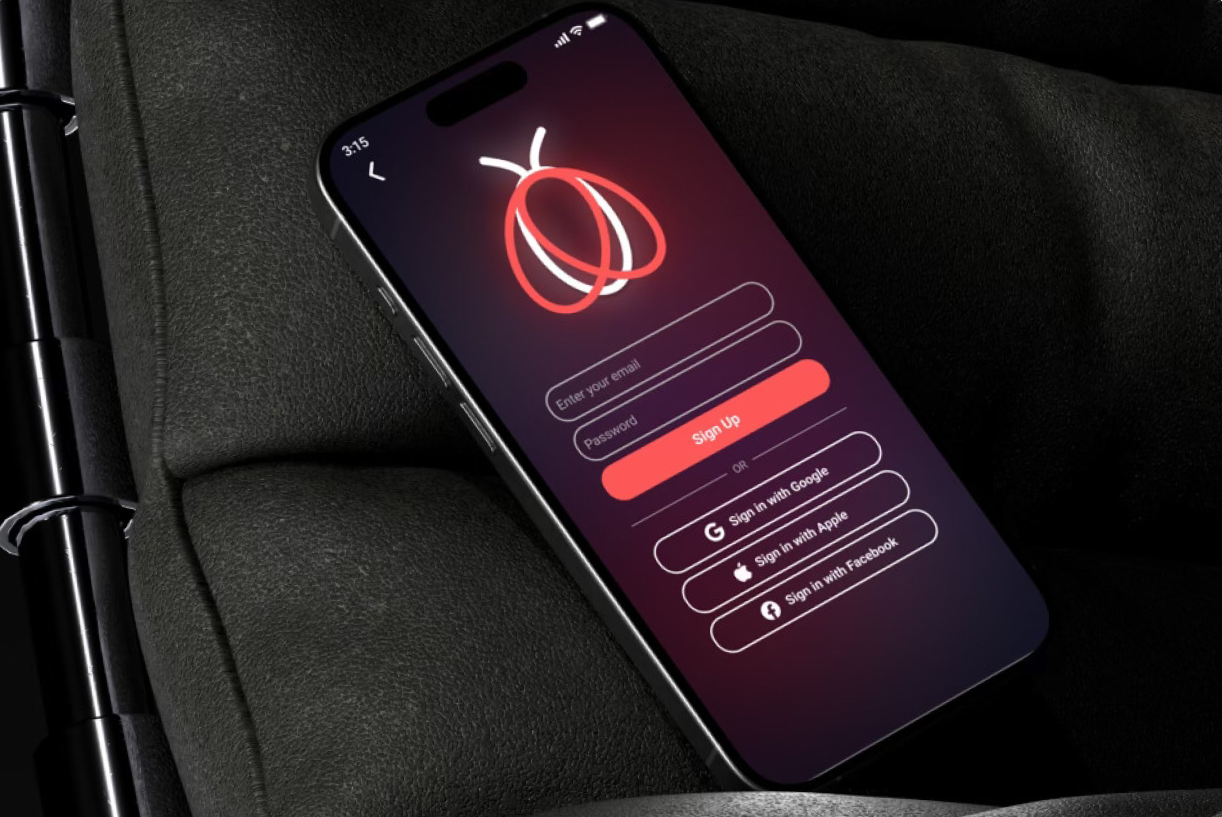Smartphone displaying a login screen for a dating app featuring a red and white logo with a stylized moth illustration, placed on a dark textured surface.