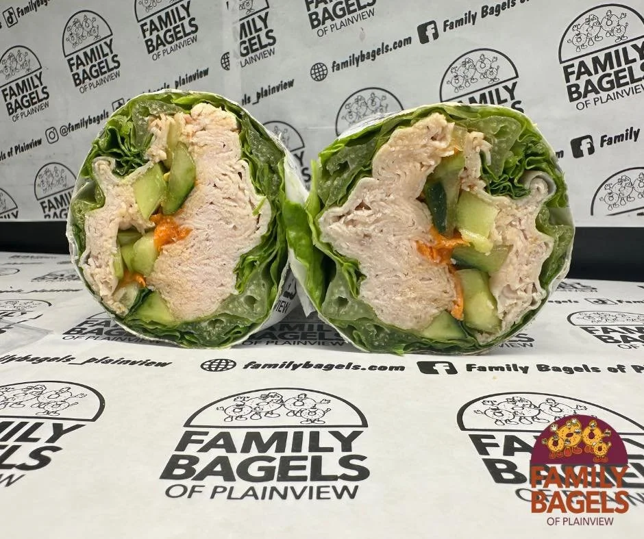 Cross-section of a chicken salad wrap with lettuce, cucumber, and carrots from Family Bagels of Plainview