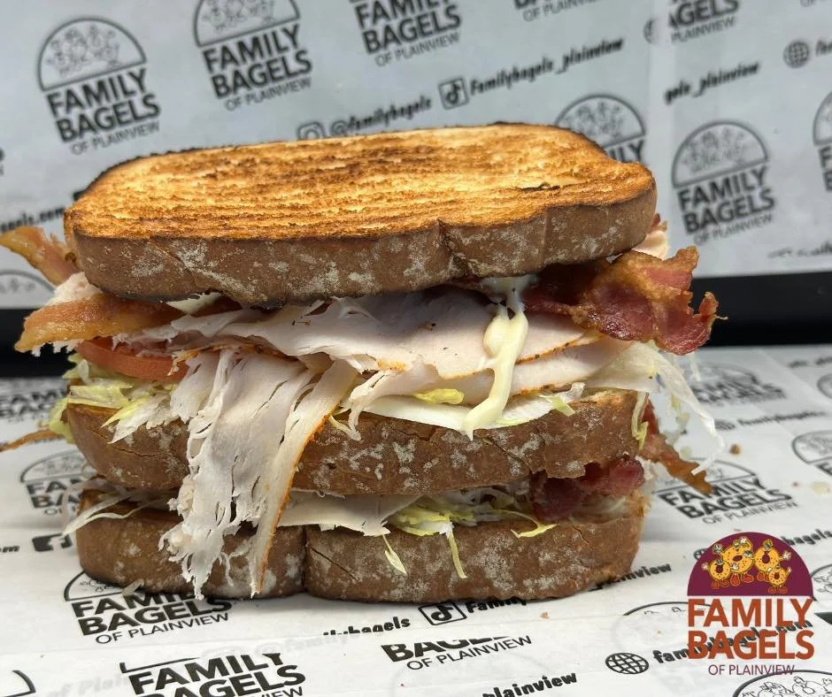 A grilled sandwich with turkey, bacon, lettuce, and tomato on toasted bread.