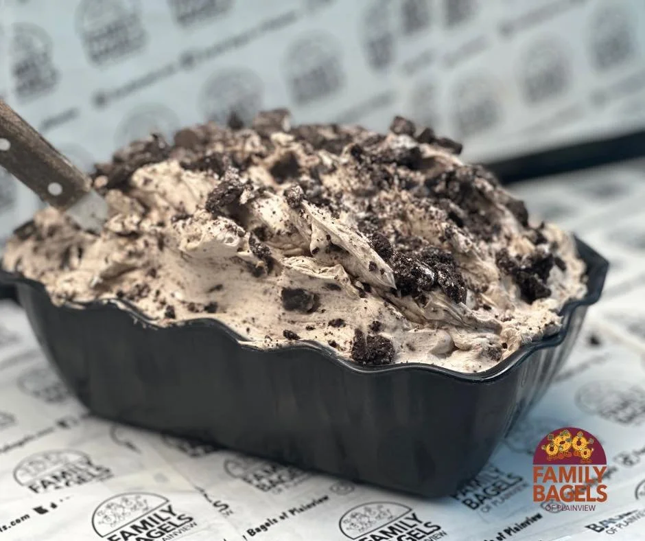 Oreo ice cream in a black container topped with crushed Oreo cookies, with a scoop in the ice cream, on branded paper from Family Bagels.