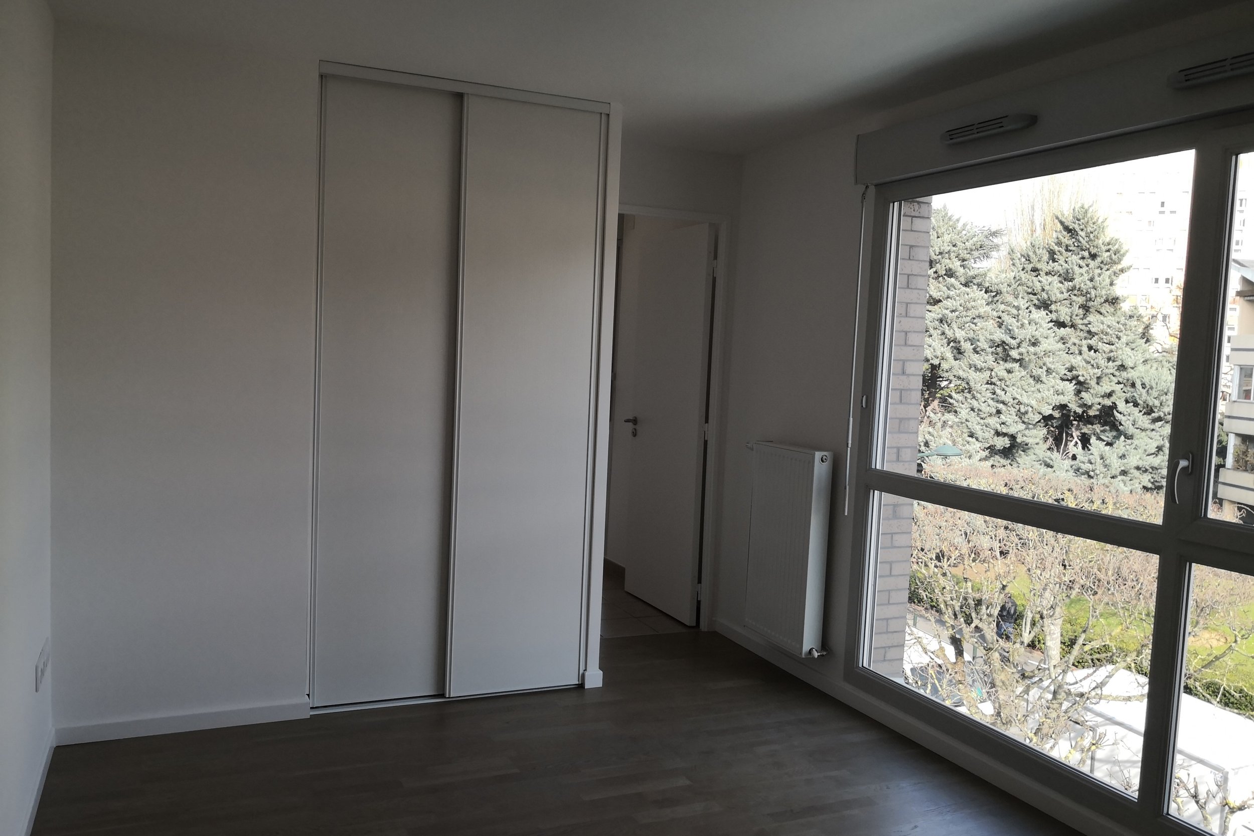 Photo avant travaux de l'espace salon dans un studio à Alfortville, futur emplacement d'un meuble de bureau sur mesure.