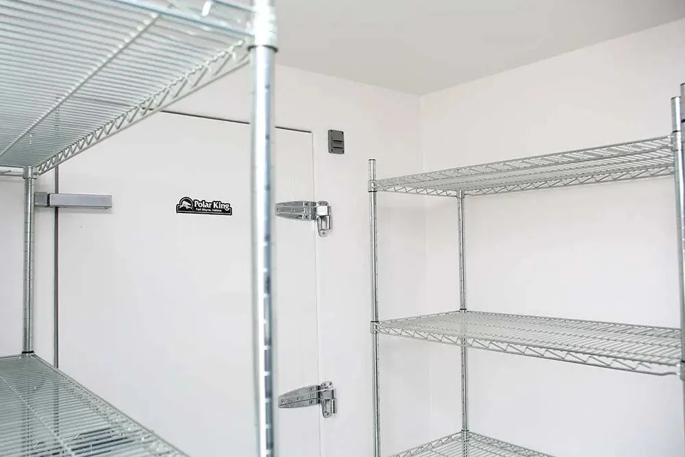 Inside a storage closet with empty wire shelves and a white door with a Polar King sticker.