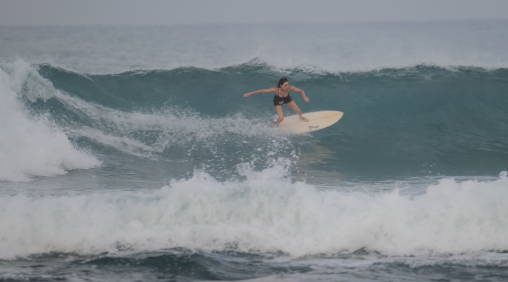 A woman surfing on a wave in the ocean