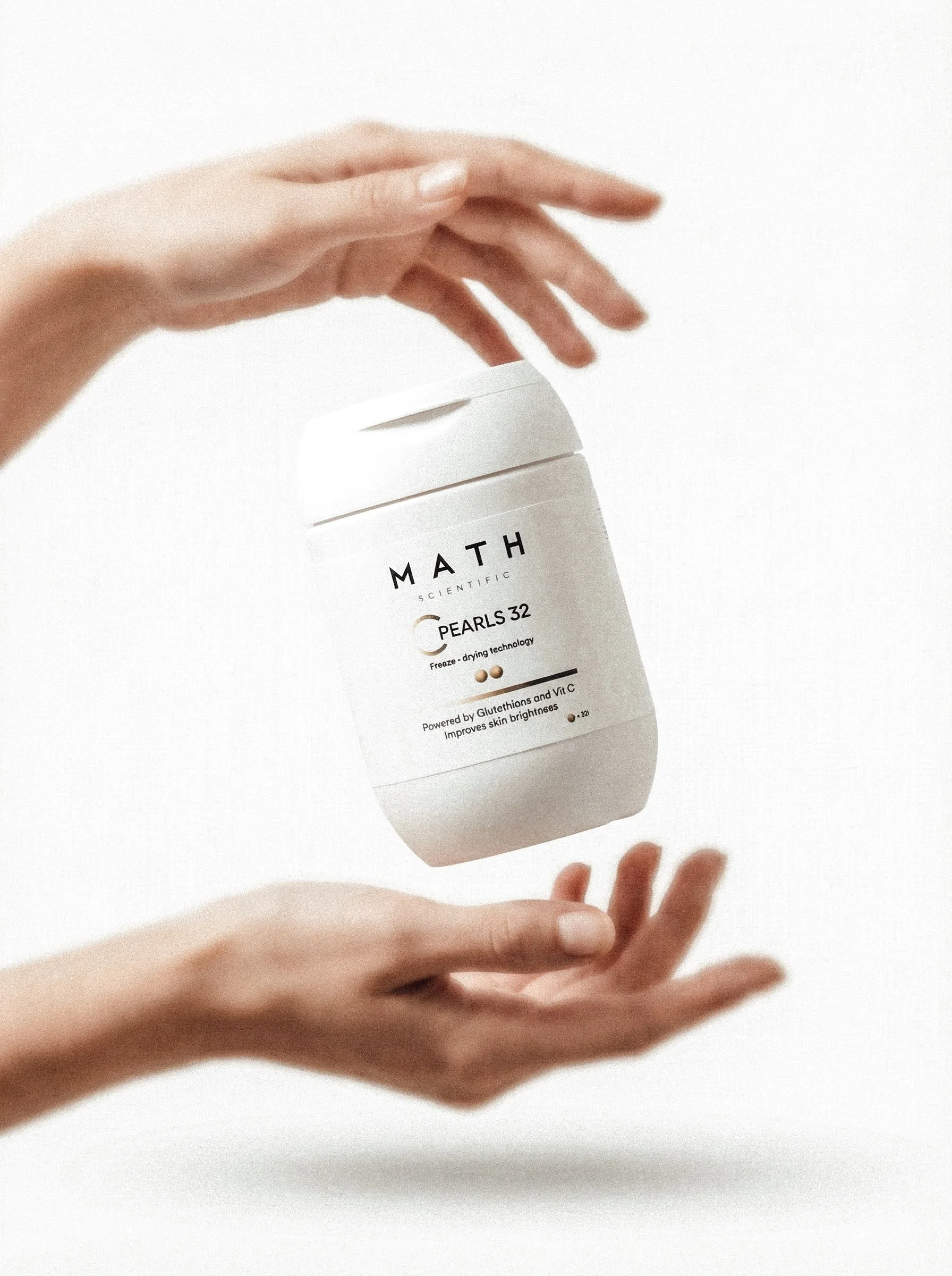 A person's hand holding a bottle labeled 'MATH' with some additional text, against a plain white background.