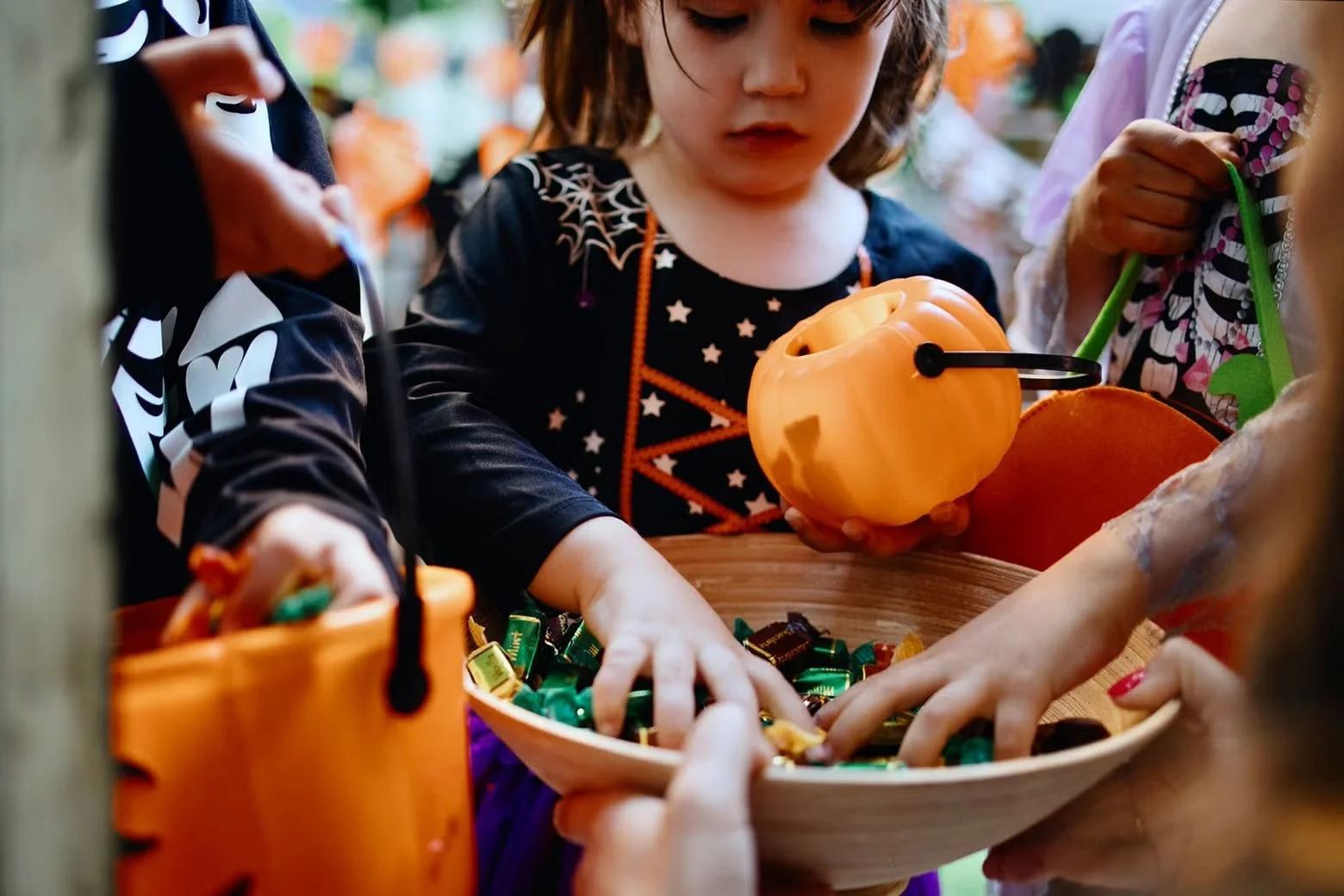 Kids grabbing candy out of a bowl on Halloween