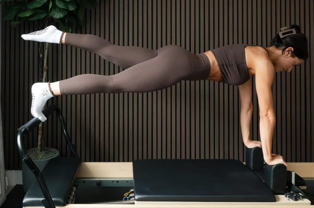 An instructor demonstrating a standing series on the reformer