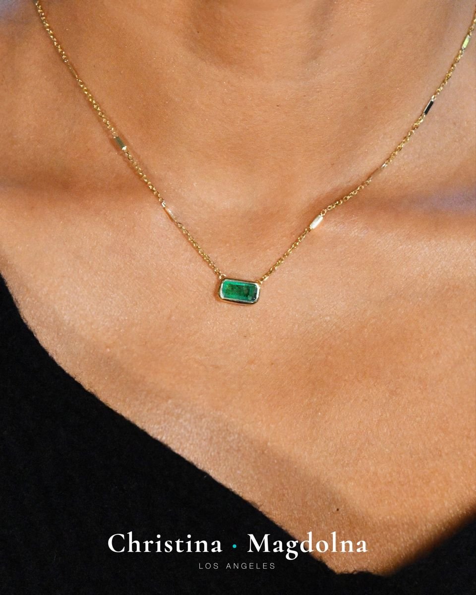 A close-up of a woman wearing a delicate gold chain necklace with a green Selah Stone pendant, demonstrating the elegant and wearable nature of our memorials.