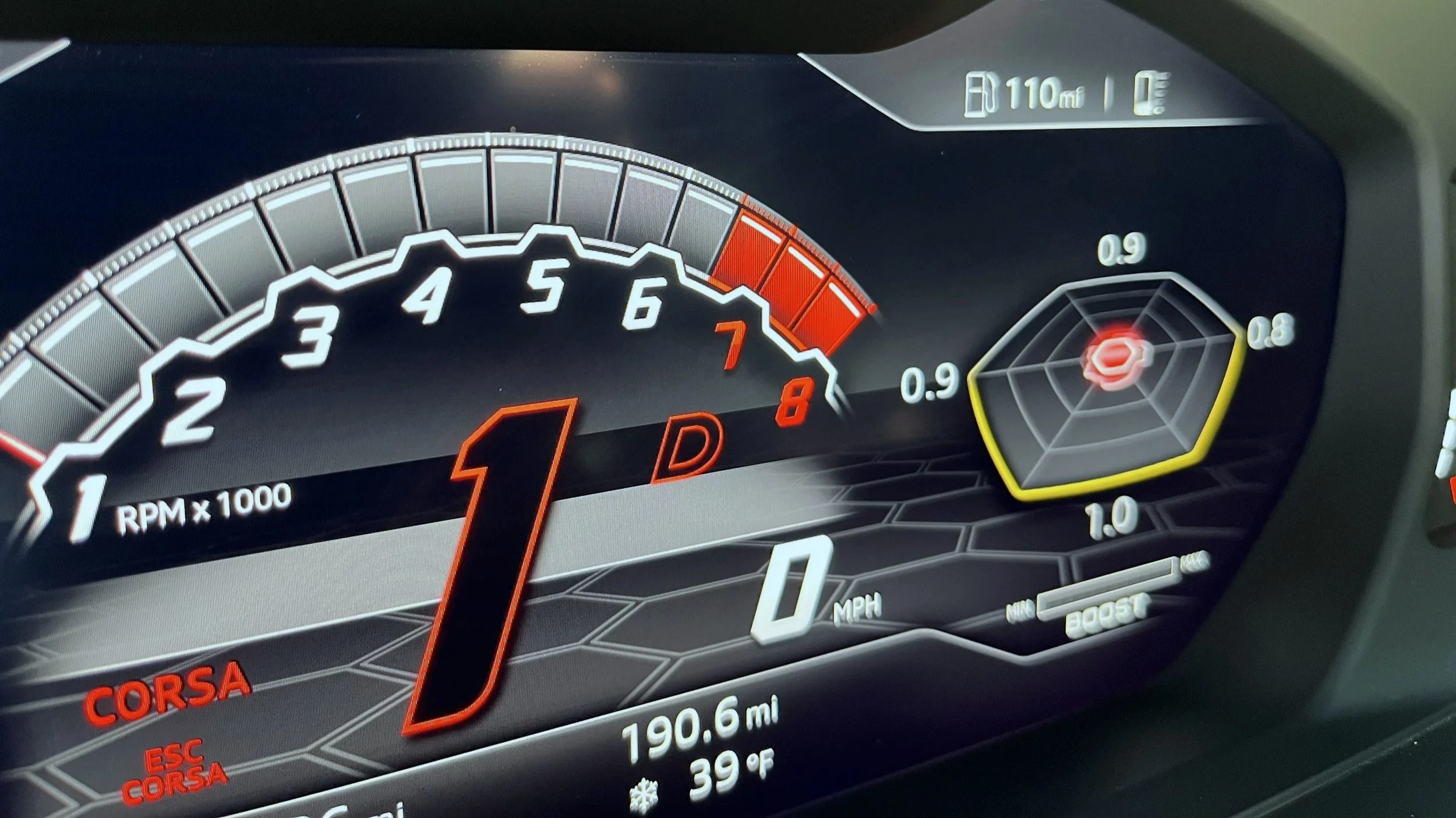 Digital car dashboard display showing RPM at around 1,000, speed at zero MPH, fuel range of 110 miles, and various navigation and engine status indicators.