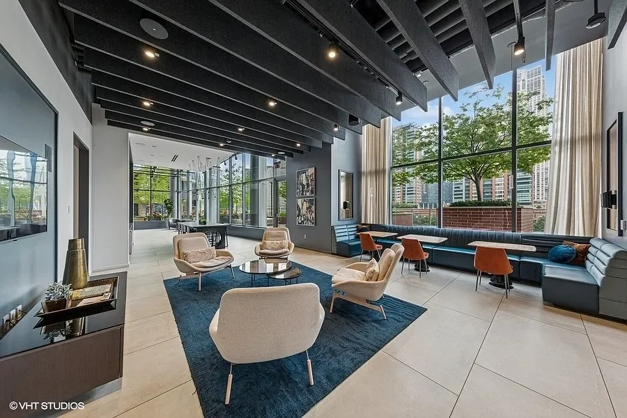 Modern hotel or office lobby with large windows, contemporary seating, and cityscape view.