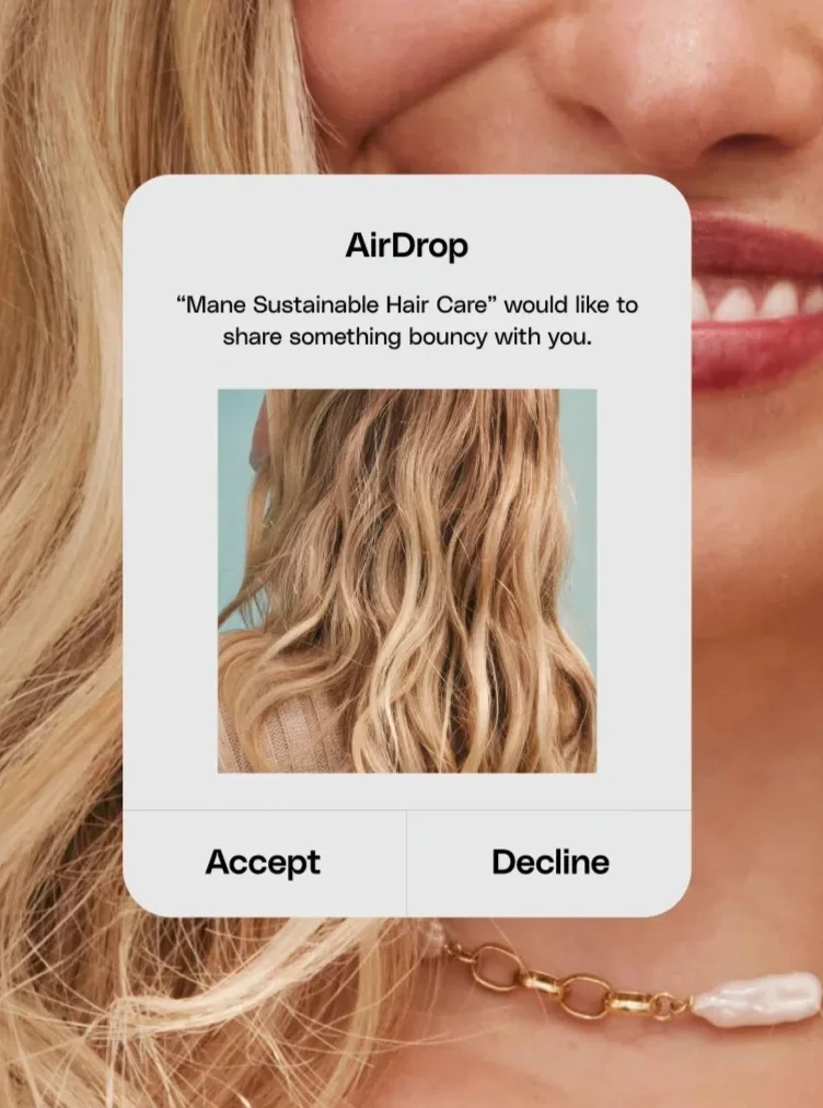 Social media notification on a phone screen showing a photo of wavy blonde hair and options to accept or decline a share request from 'Mane Sustainable Hair Care' for a bounce-worthy hair care routine.