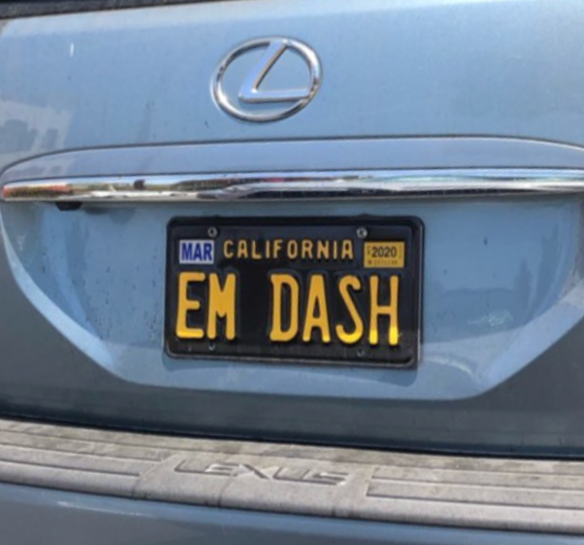Close-up of a blue Lexus car rear with a California license plate reading 'EM DASH' and a Lexus logo above.