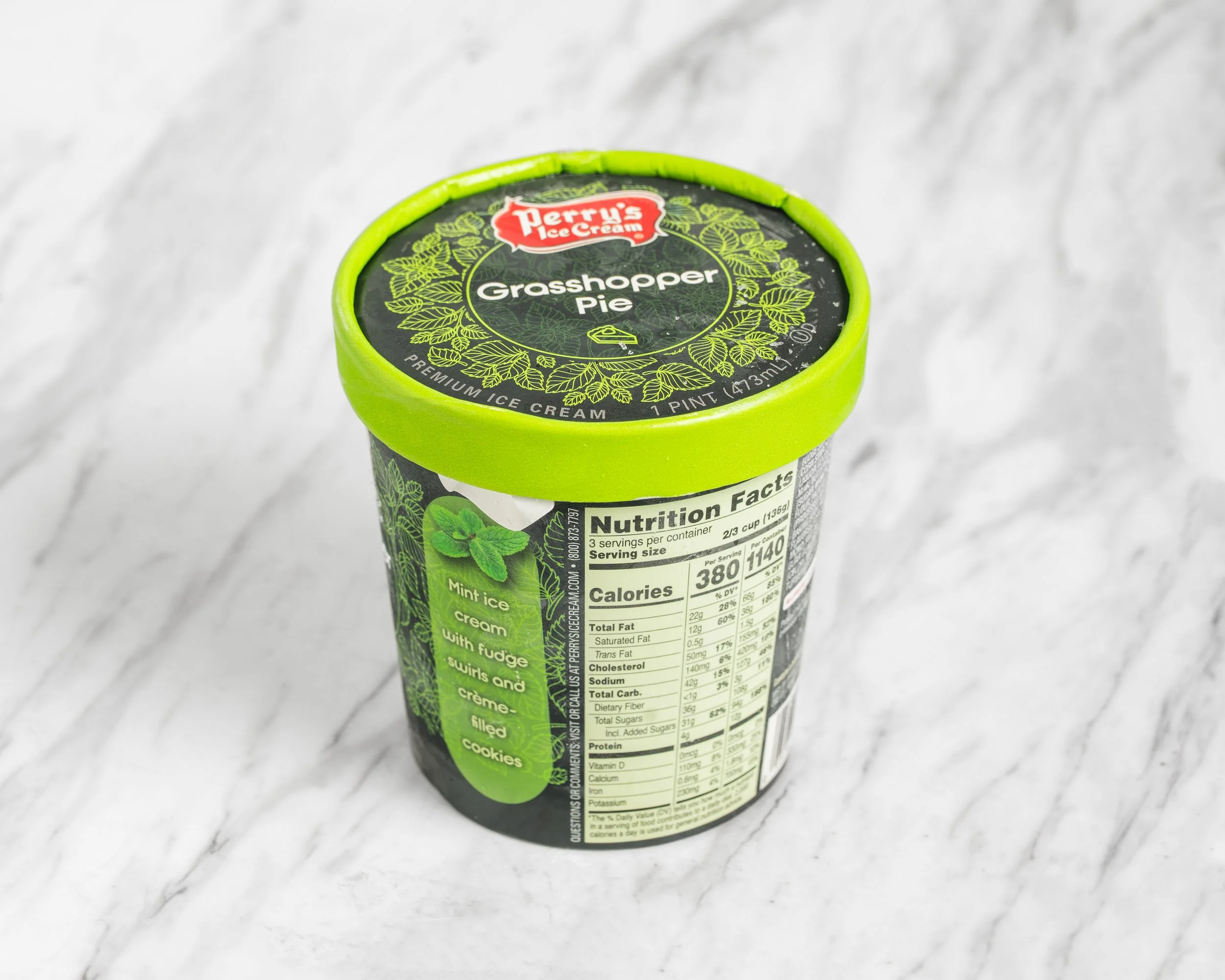 Green container of Perry's Ice Cream Grasshopper Pie flavor on a marble countertop.