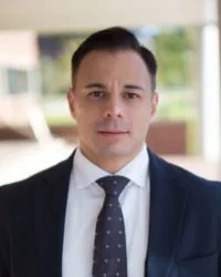 Portrait of a man in a suit and tie outdoors with blurred background