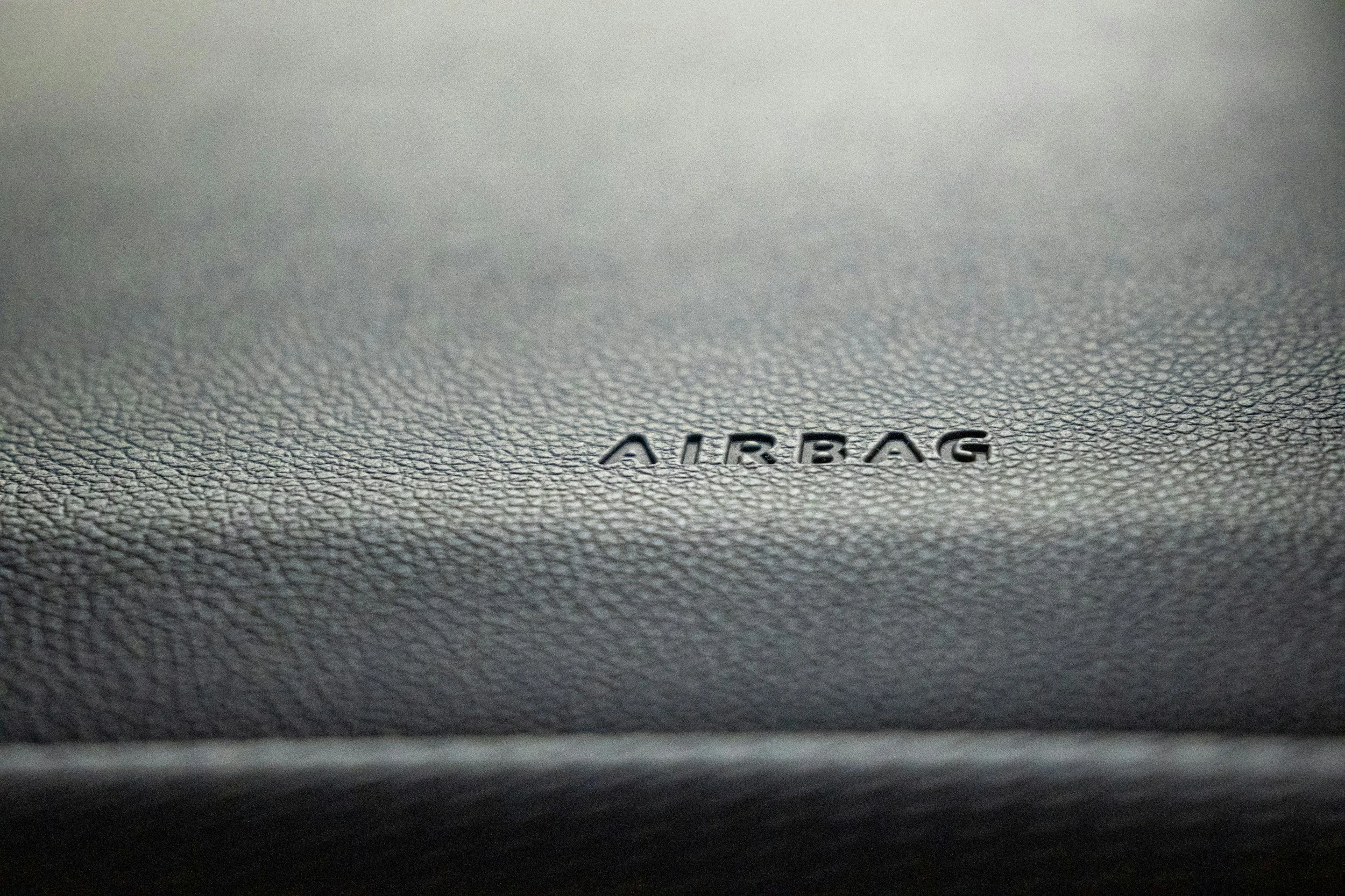 Close-up of textured gray surface with the word 'AIRBAG' embossed in black