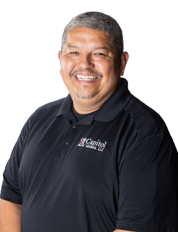 Smiling man with gray hair and goatee wearing a black polo shirt with a logo for Capitol Buys Houses, LLC.