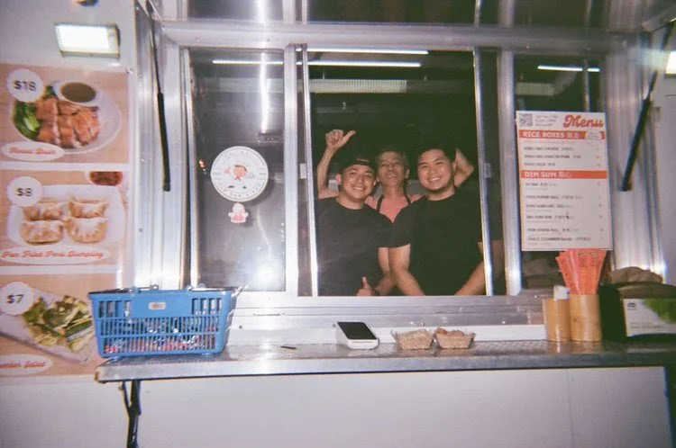 Kai Kai staff inside food truck smiling and waving
