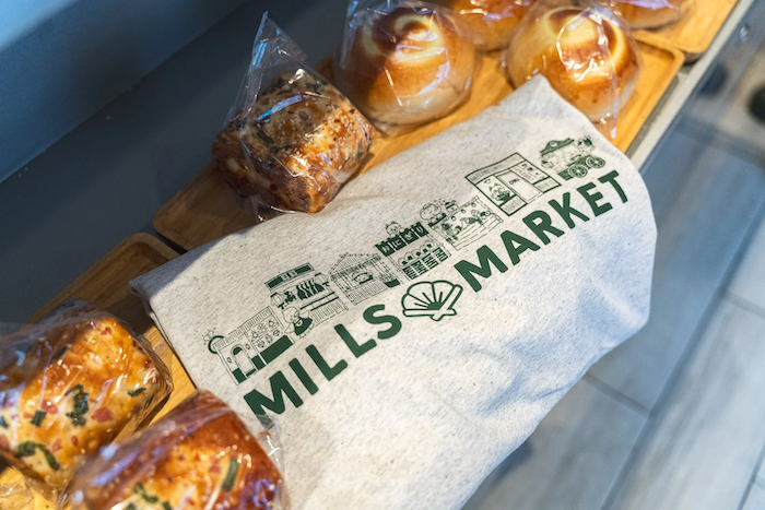 mills-market-branded-tshirt-folded-near-fresh-bakery-pastries.png