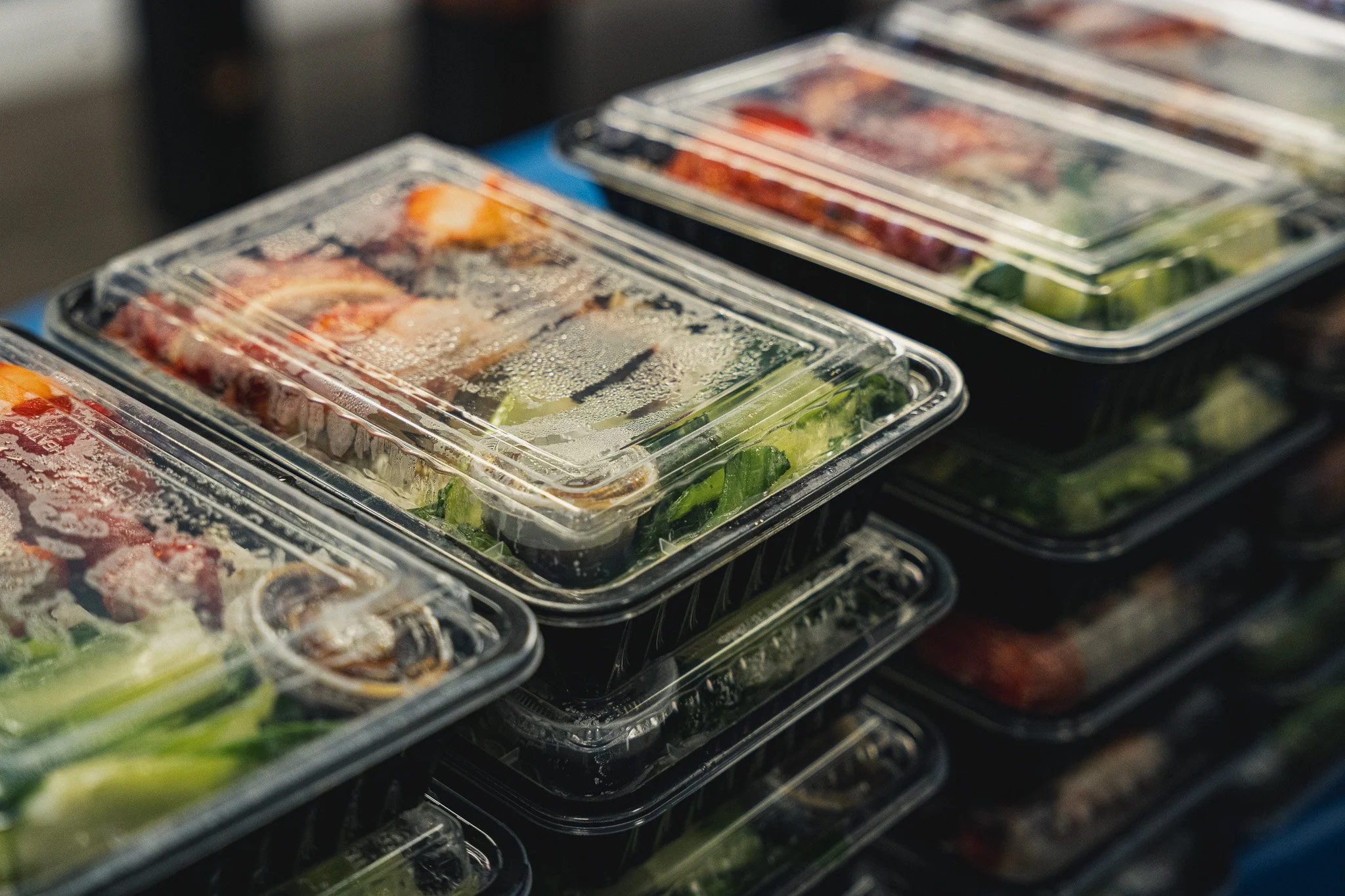 rows of stacked hot boxed meals containing chicken, rice and vegetables. 