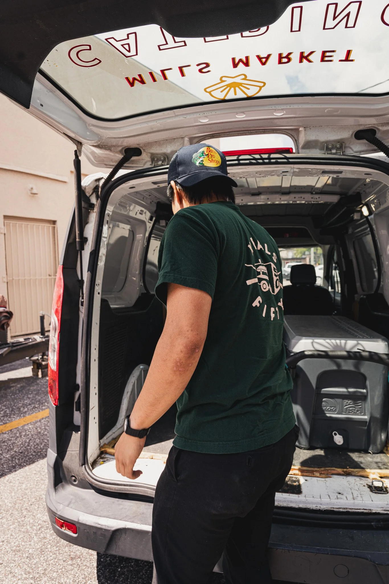 Meals 50 team member wearing green meals 50 logo shirt unloads catering van 