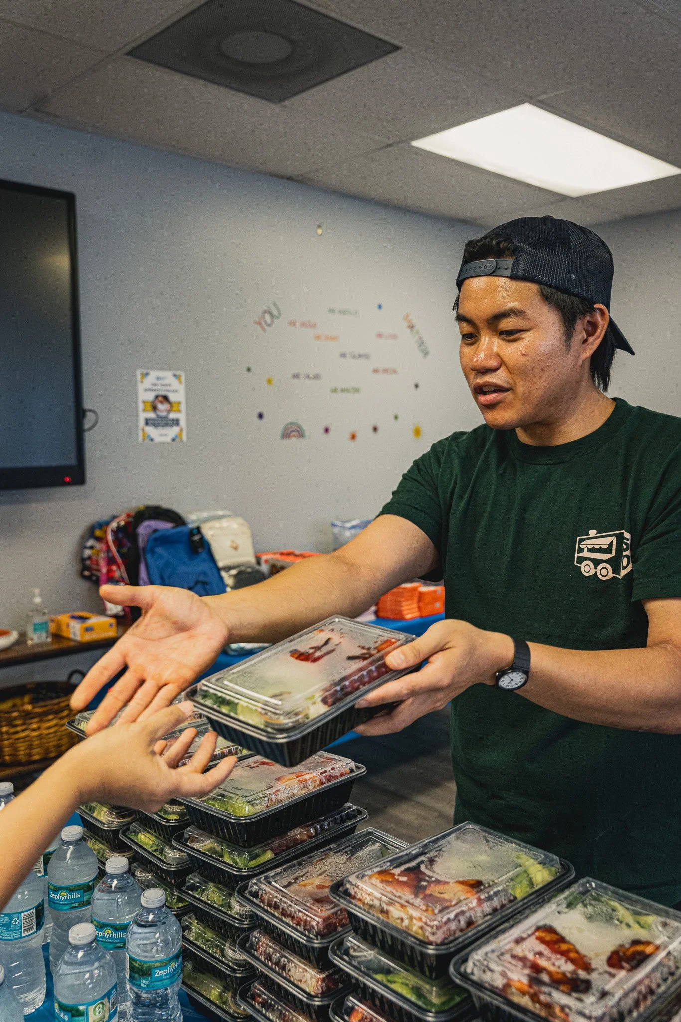 meals 50 team member handing an individual meal over a table to someone. 