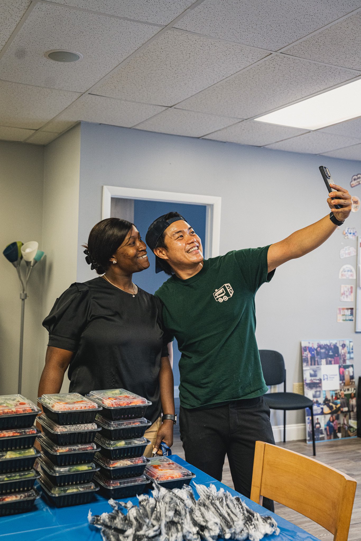 meals 50 team member and a woman wearing a black t shirt taking a selfie. 
