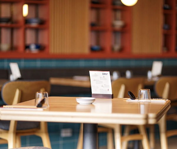 Zaru restaurant table with utensils, glasses, and a menu in a cozy dining area.
