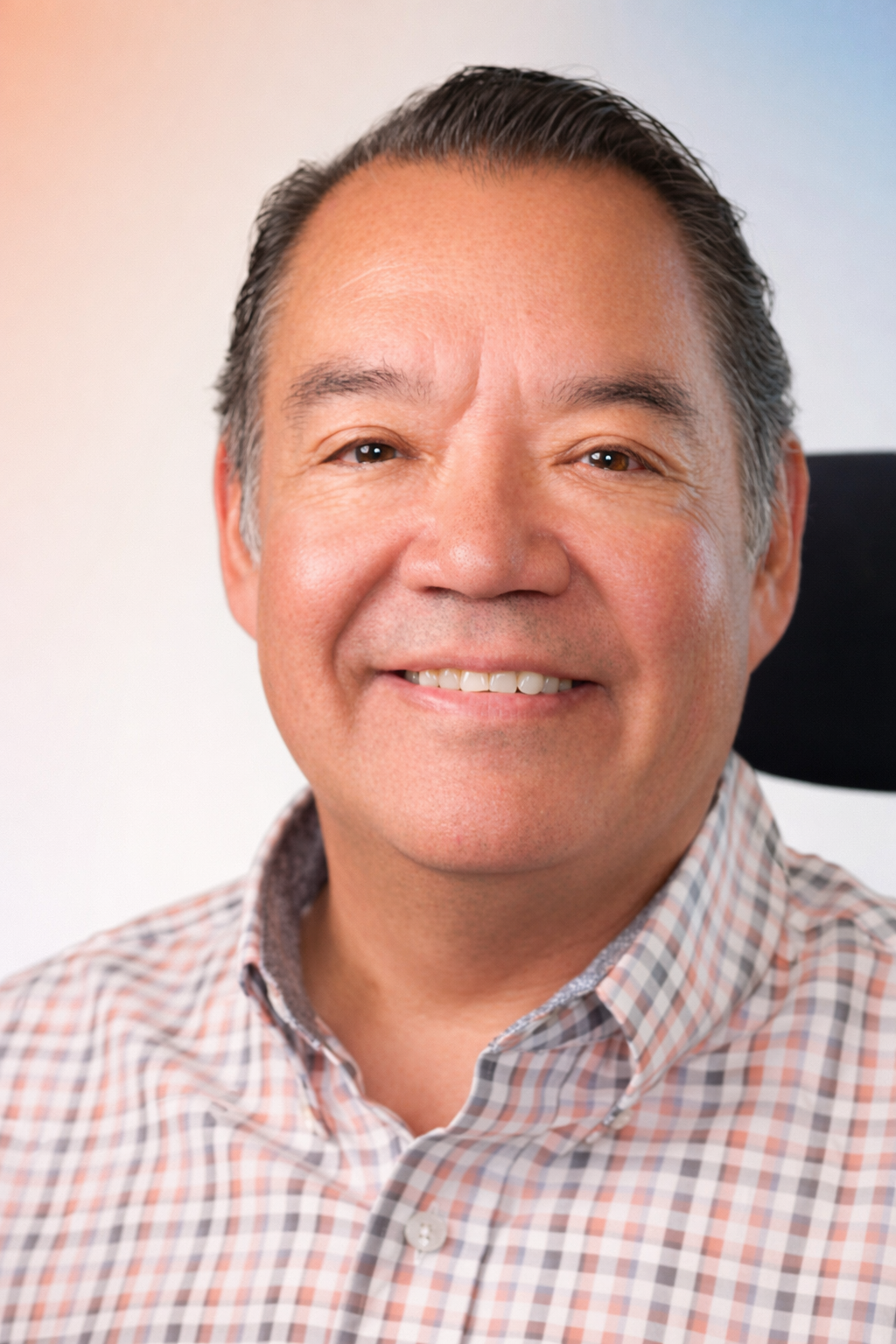 Portrait of Franklin Ouchida, President of the Board of Directors for the Social Advocacy Network of Disabilities (SAND), smiling at the camera.