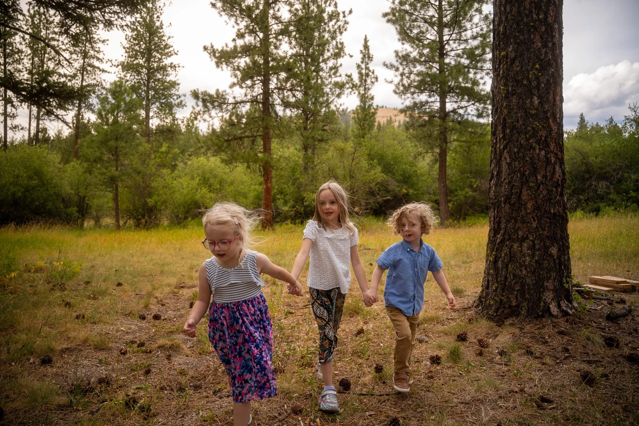 3 kids playing and running in Pattee Canyon Forest