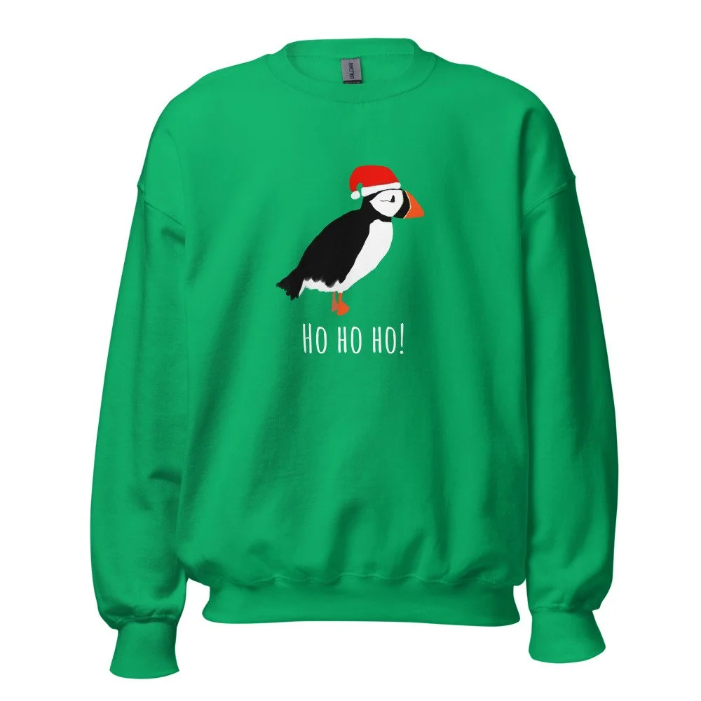 Green Christmas sweater featuring a cartoon penguin wearing a Santa hat, with the text "HO HO HO!" beneath it. Holiday Shopping Bright Blue Art Company