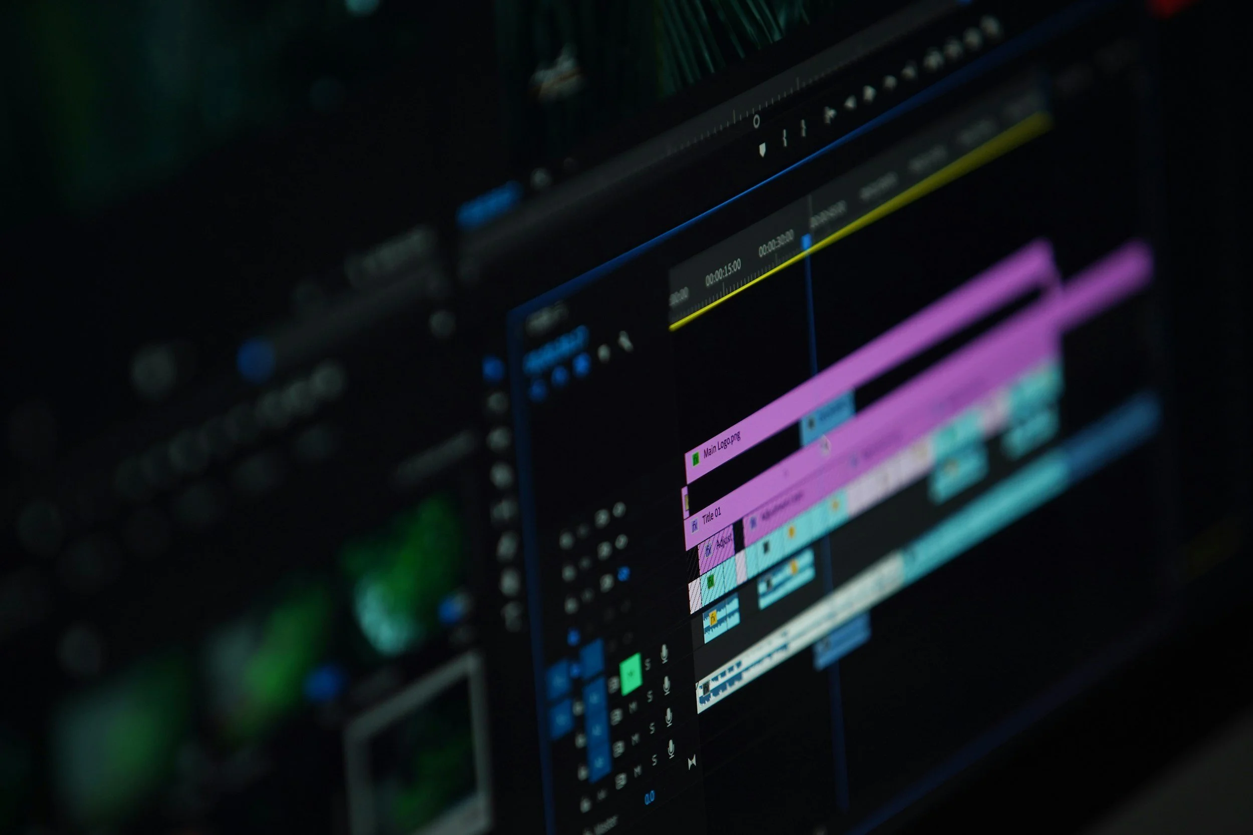 Close-up of a digital video editing software interface on a computer screen, showing multiple colored tracks, timelines, and editing controls.