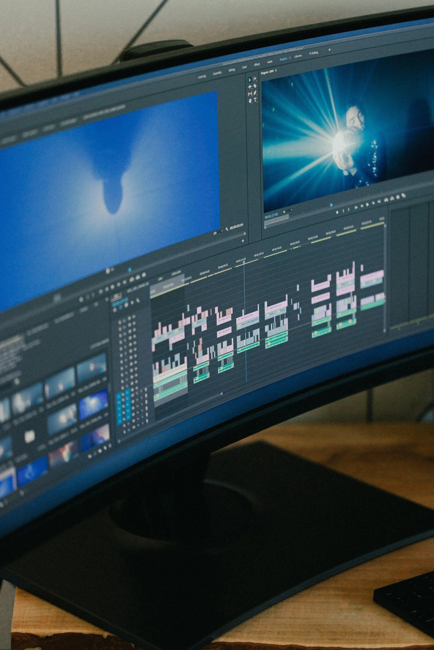 Photo of a computer monitor displaying video editing software with clips, timelines, and an image of a person holding a bright light source.