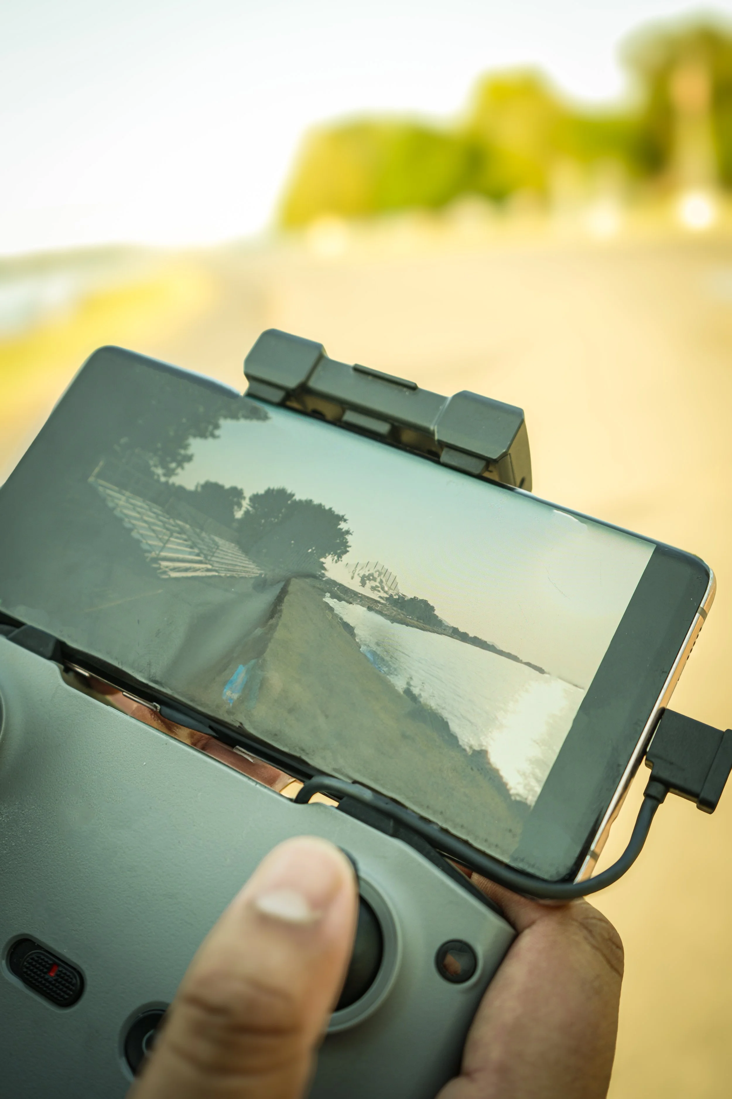 Drone pilot operating aerial cinematography remote controller for professional video production