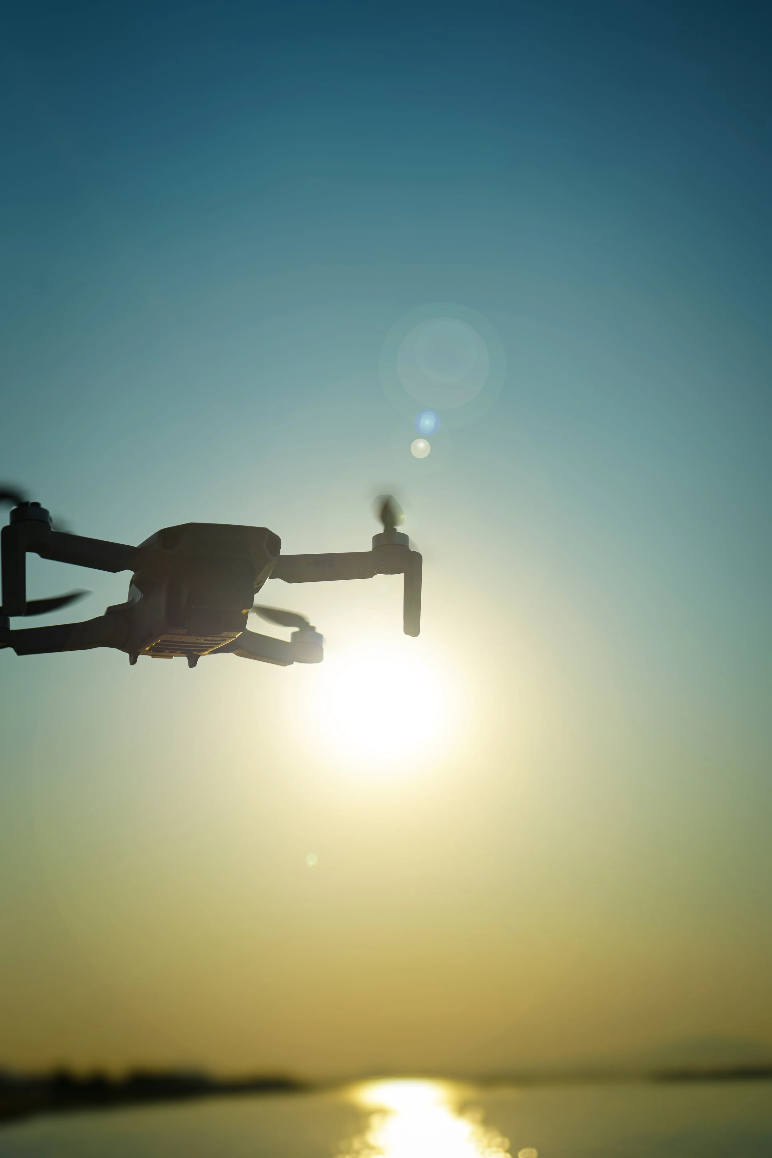 Professional aerial cinematography drone capturing cinematic footage at sunrise for ARC Lens Productions