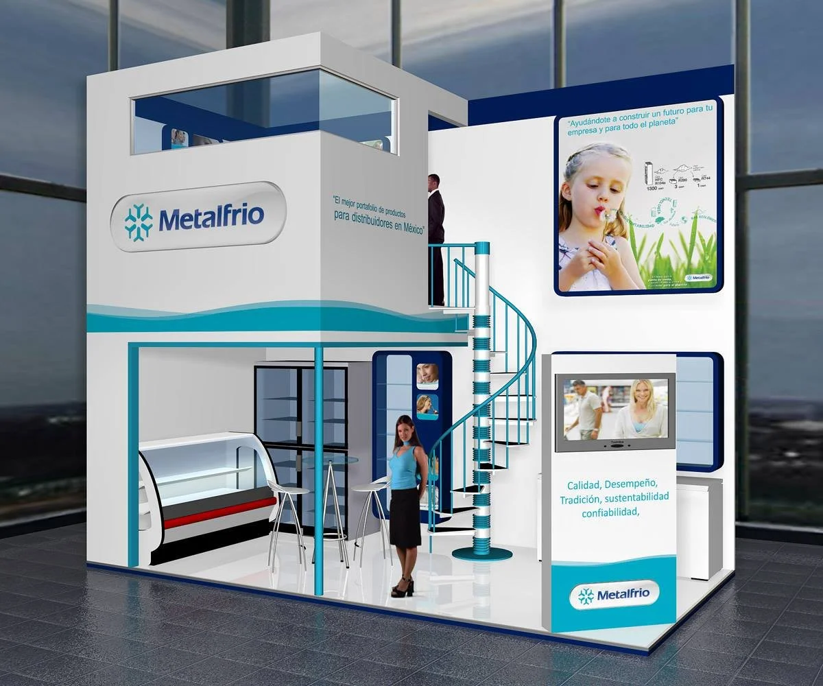 Stand de exhibición de Metalfrio en una feria, con estructura moderna blanca y azul, escaleras de caracol, pantallas con información, y una mujer y un niño en el interior