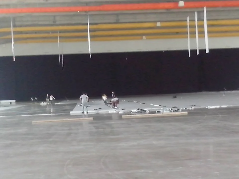 Personas trabajando en una construcción bajo un puente o estructura elevada.