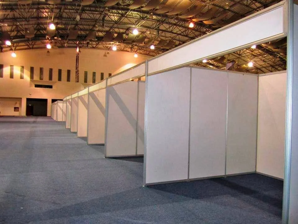 Pasillos vacíos en una feria o exhibición con paneles blancos y techo metálico