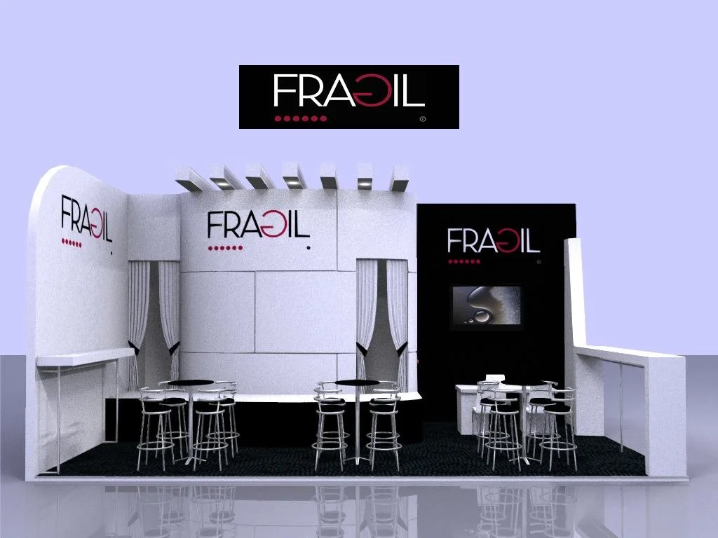 Stand de exhibición con marcas FRAEIL en fondo blanco y negro, con mesas y sillas, y pantalla en la esquina derecha.