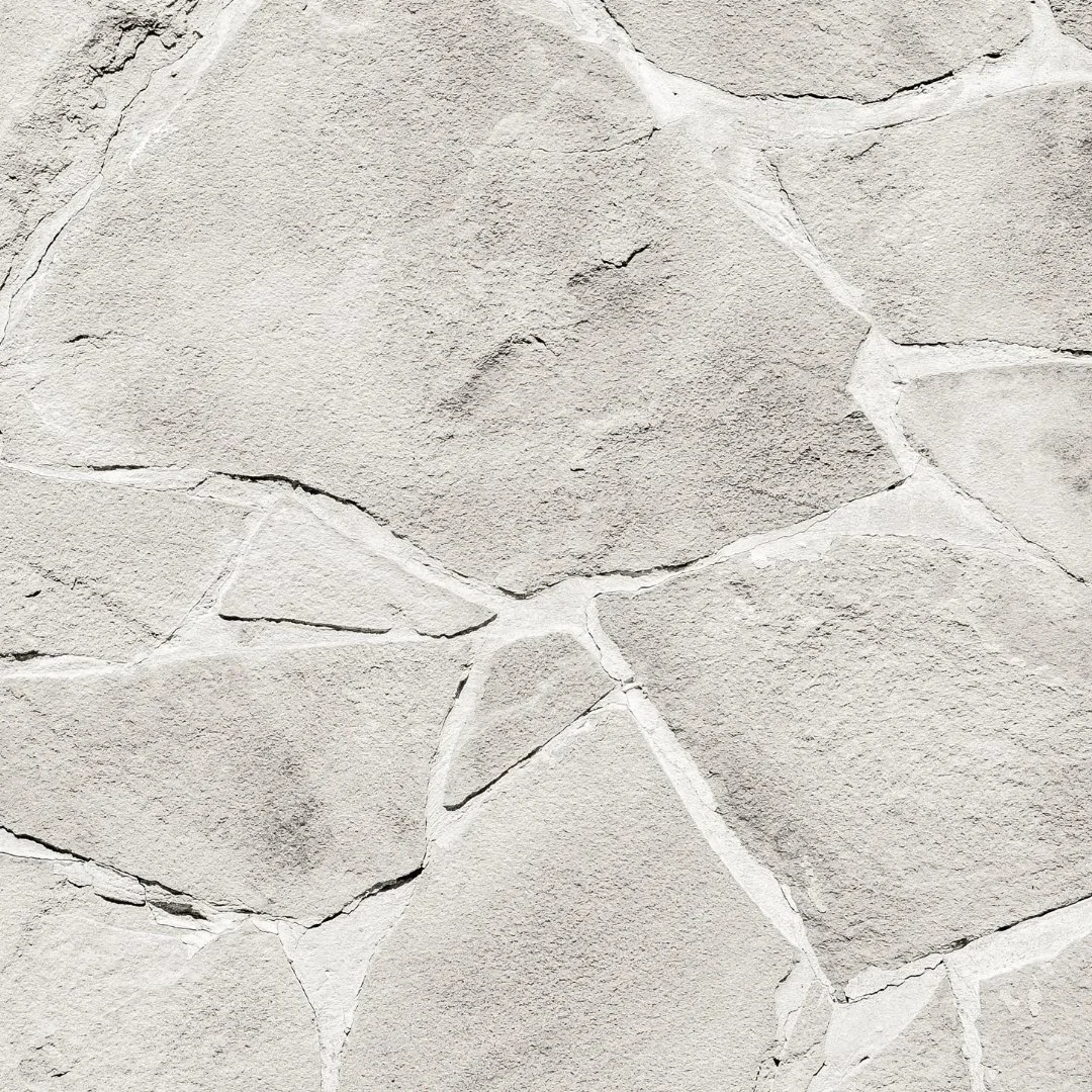 Weiße Natursteinwand mit sichtbaren Fugen als Fassadendetail