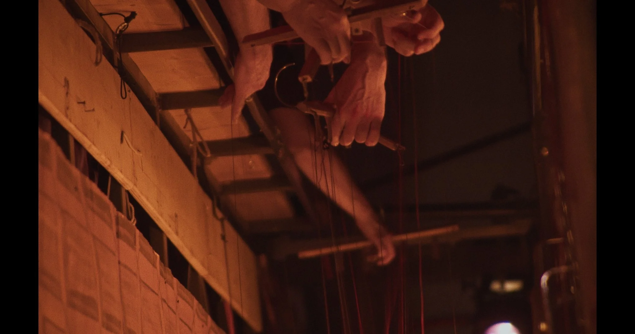 Hands of marionettists working on the bridge space photographed from backstage.
