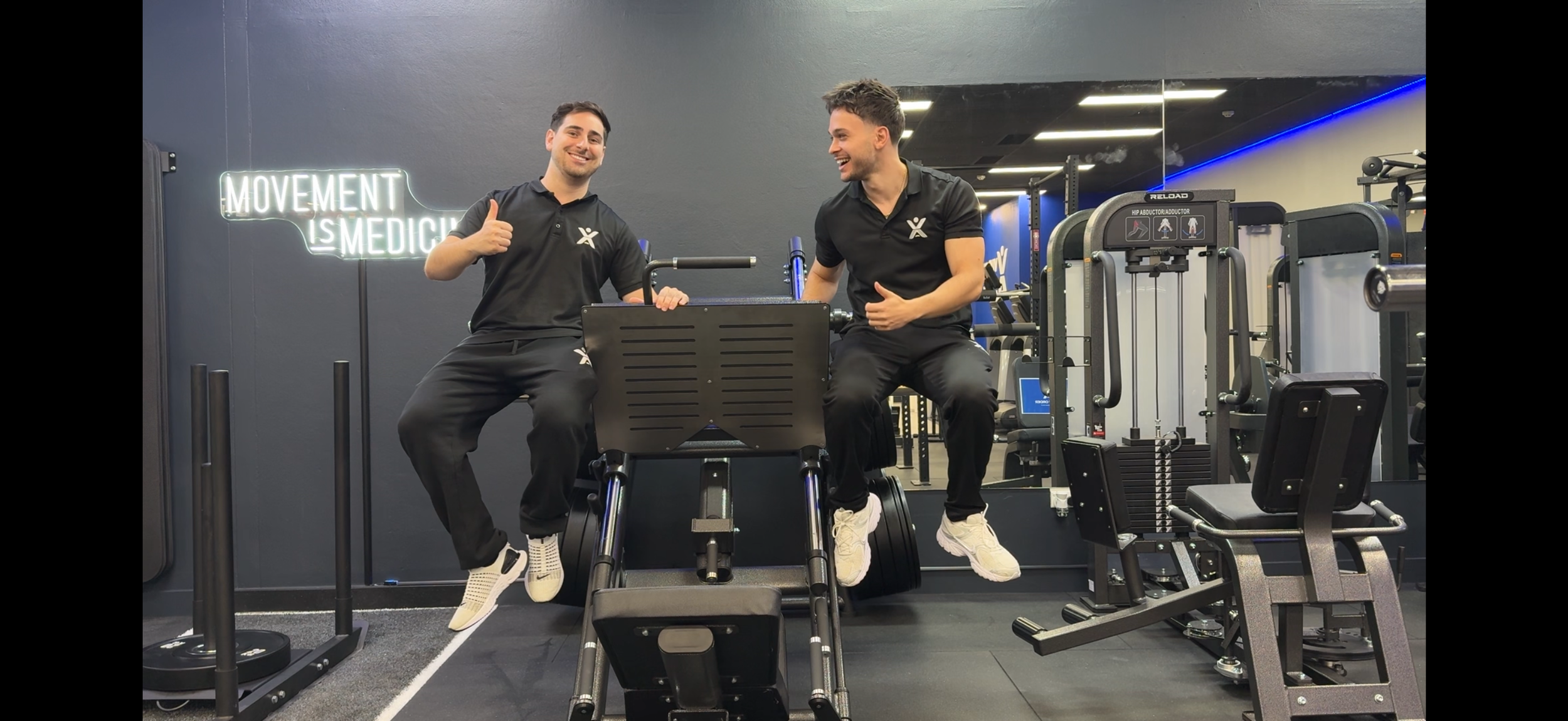 Julian Murdocca and Daniel Shalala, Viva Active founders and head trainers in the Burwood studio beneath the 'Movement is Medicine' sign