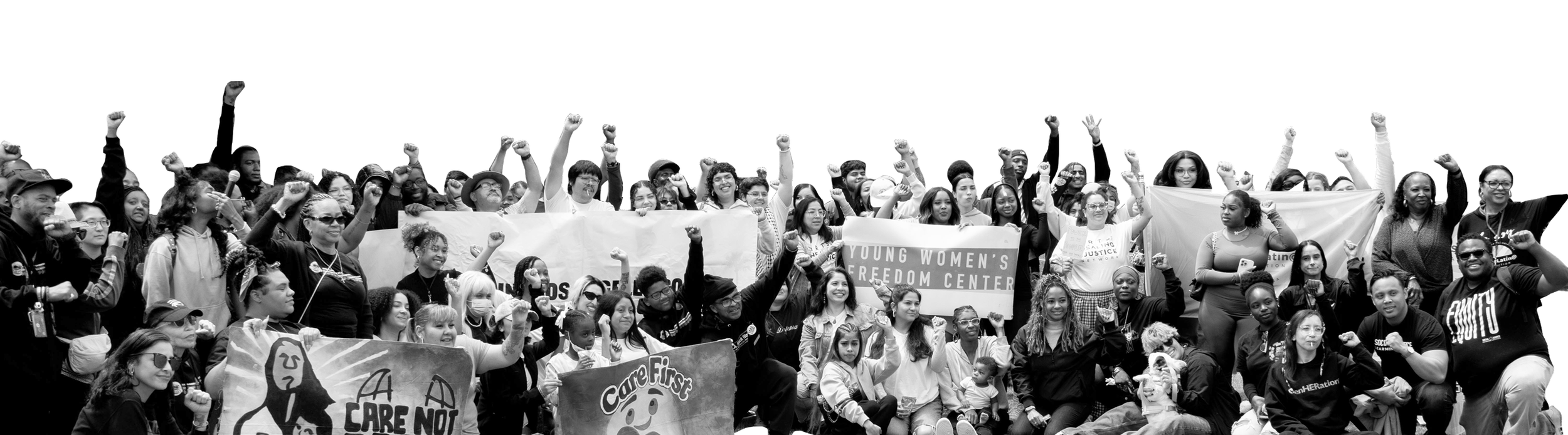 A large group of people gathered outdoors, holding banners and signs, raising their fists in the air, celebrating at a rally or protest.