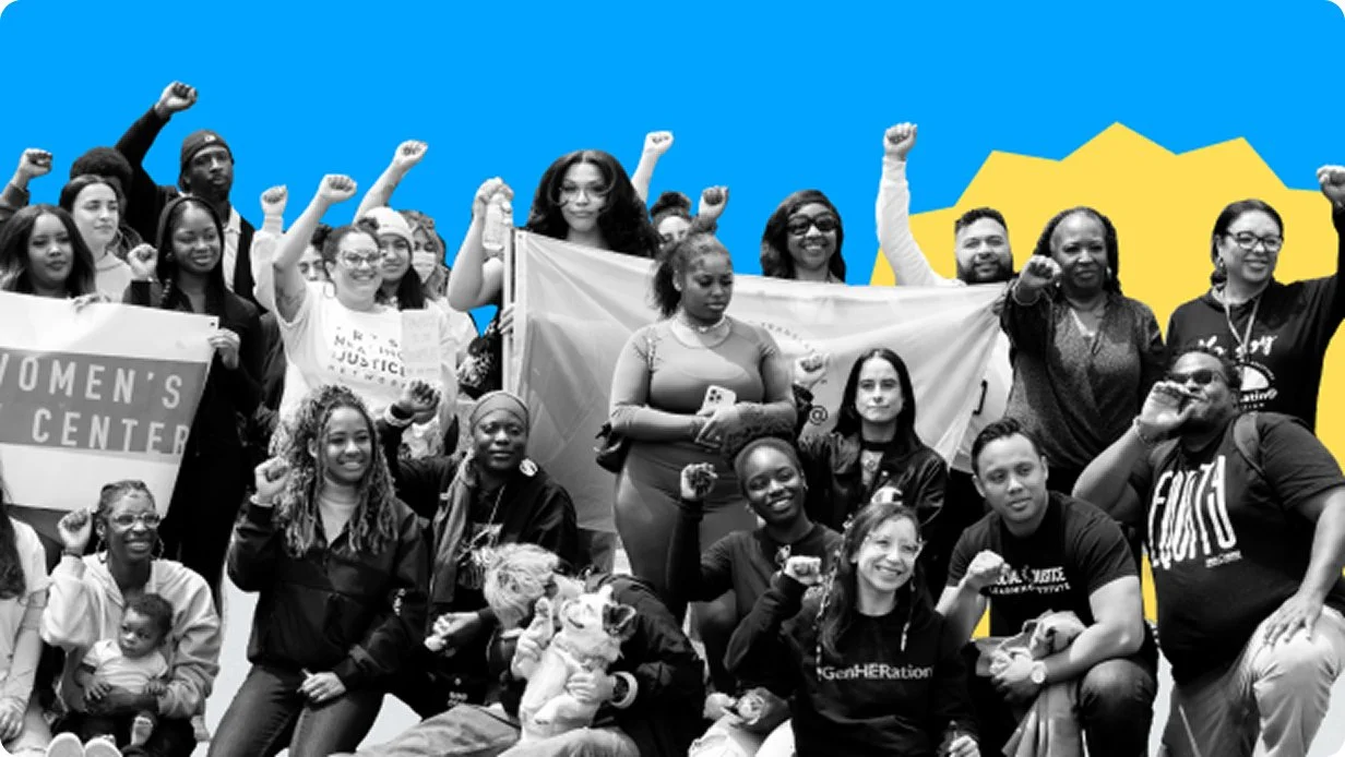 A diverse group of women and men gathered outdoors, many raising their fists in a rally or protest, with some holding signs and a woman in front holding a flag, against a colorful background.