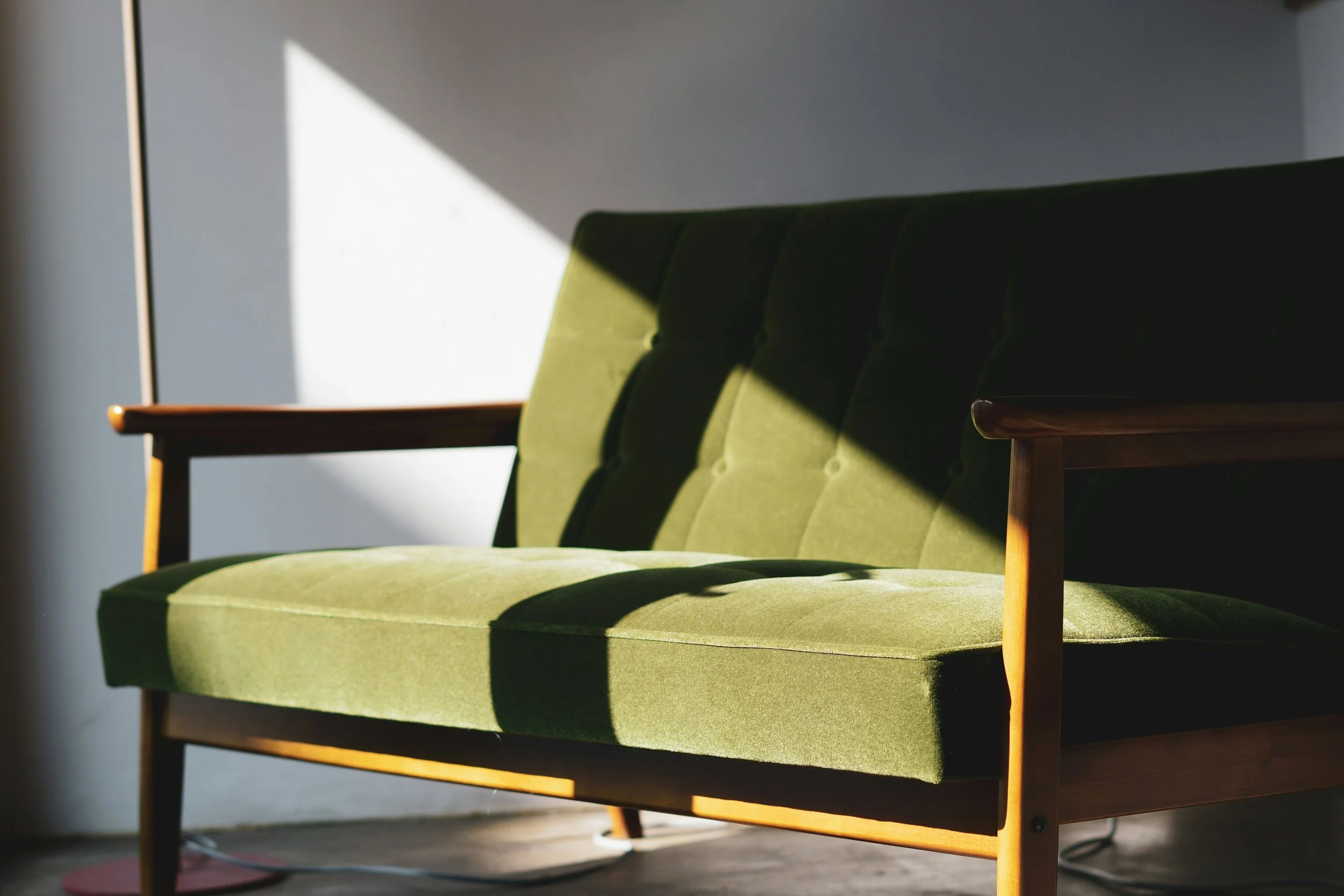 Calming green sofa in soft light offering therapeutic counselling in a quiet room in Moira