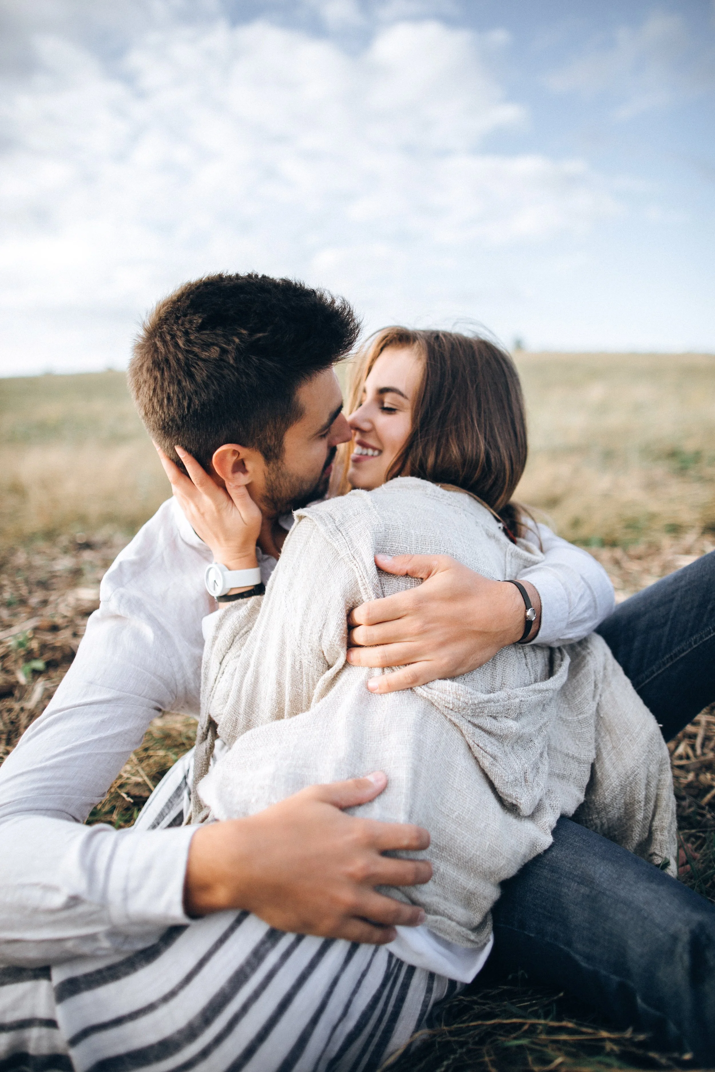 lovely-souple-hugging-kissing-smiling-against-sky-seating-grass-space-text.jpg