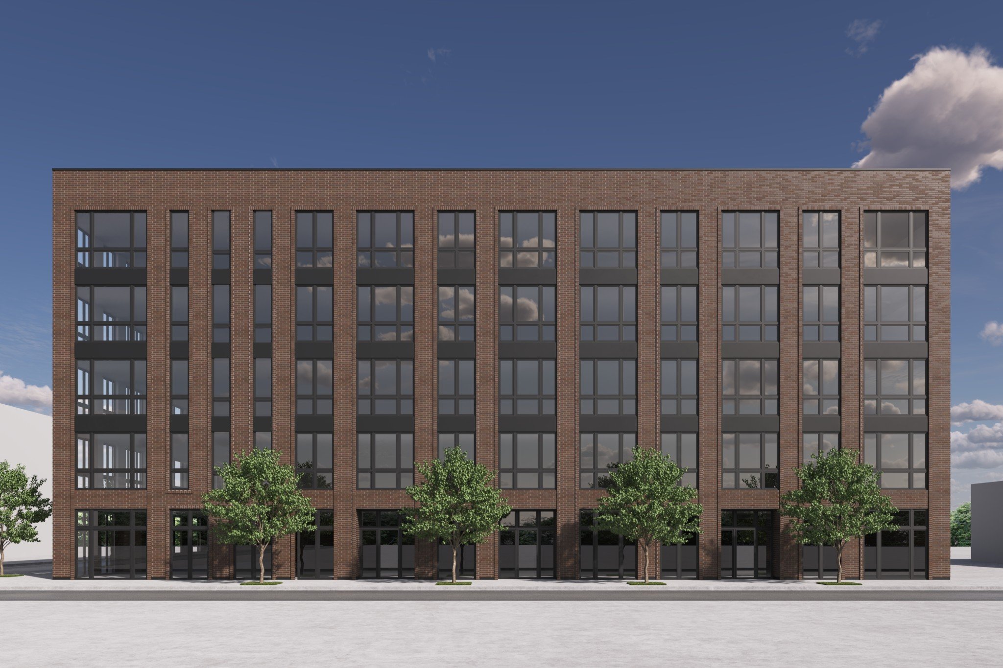 Modern, multi-story black brick apartment building with large windows, glass balconies, and retail space on the ground floor, surrounded by green trees and a street with cars and pedestrians.