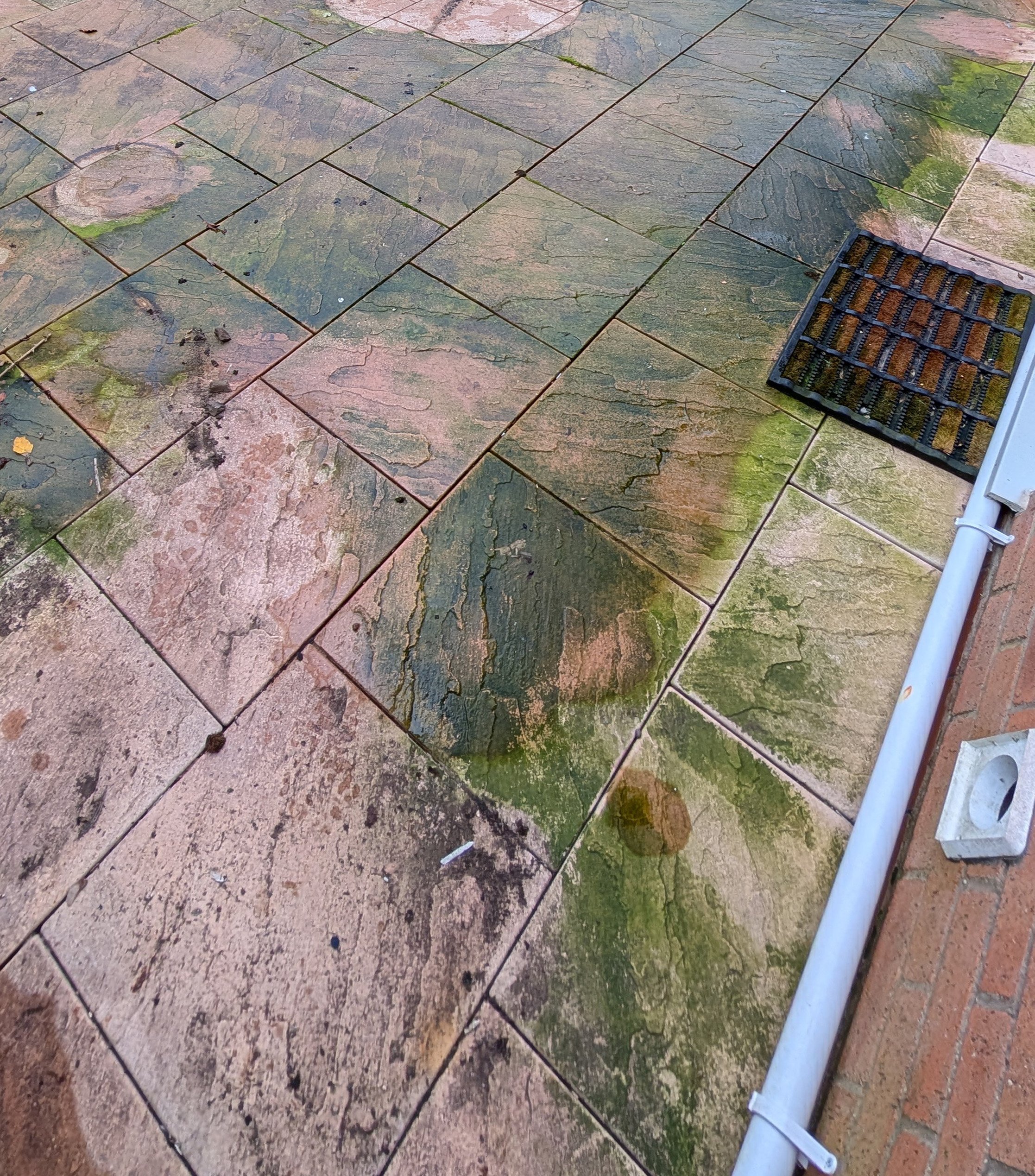 Dirty and stained outdoor stone patio with green moss and dirt before professional patio cleaning in Buckinghamshire