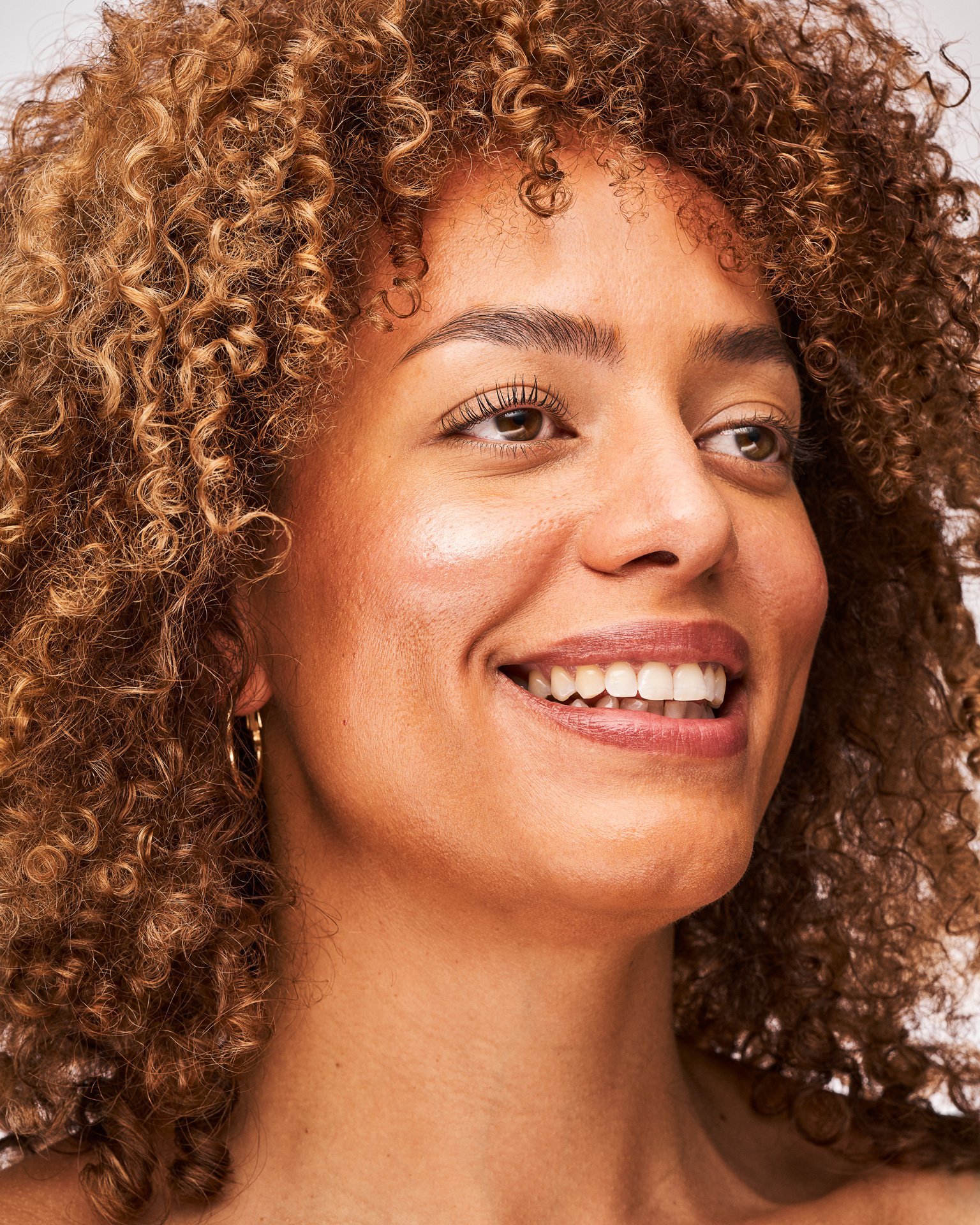 Dark skinned model smiling away form the camera.