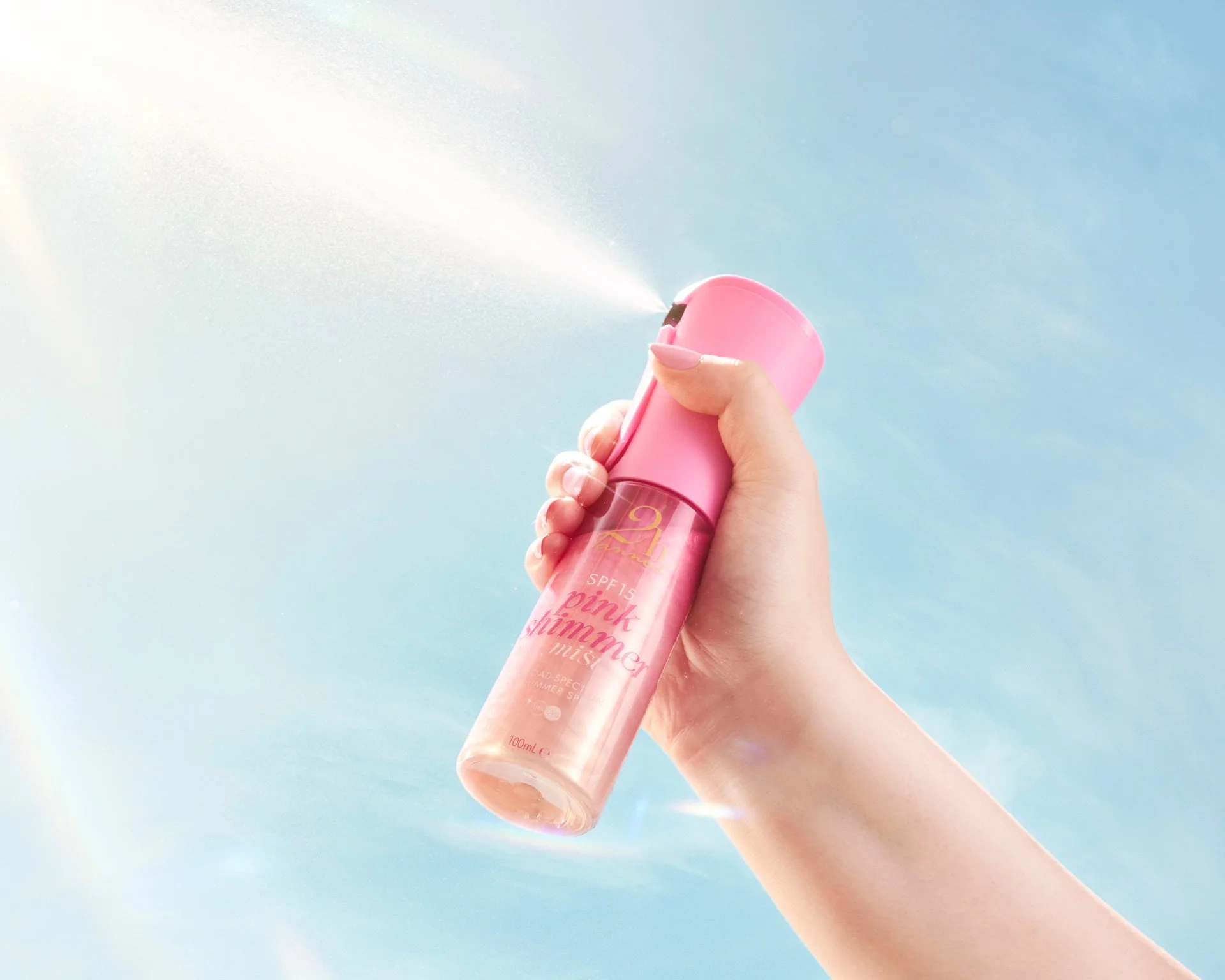Hand holding and praying pink shimmer SPF product.