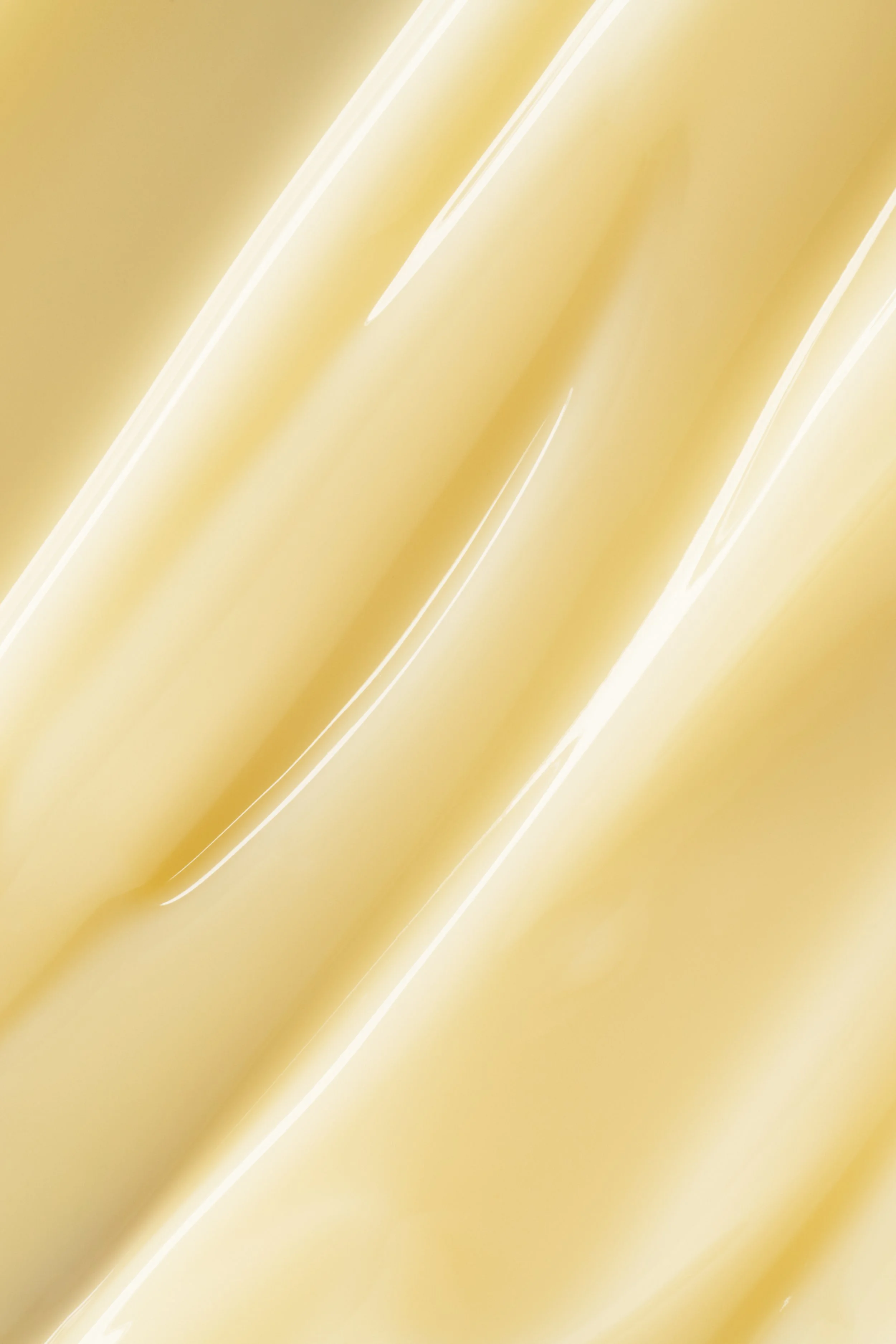 Close-up of a smooth, shiny, golden-colored surface with light reflections.