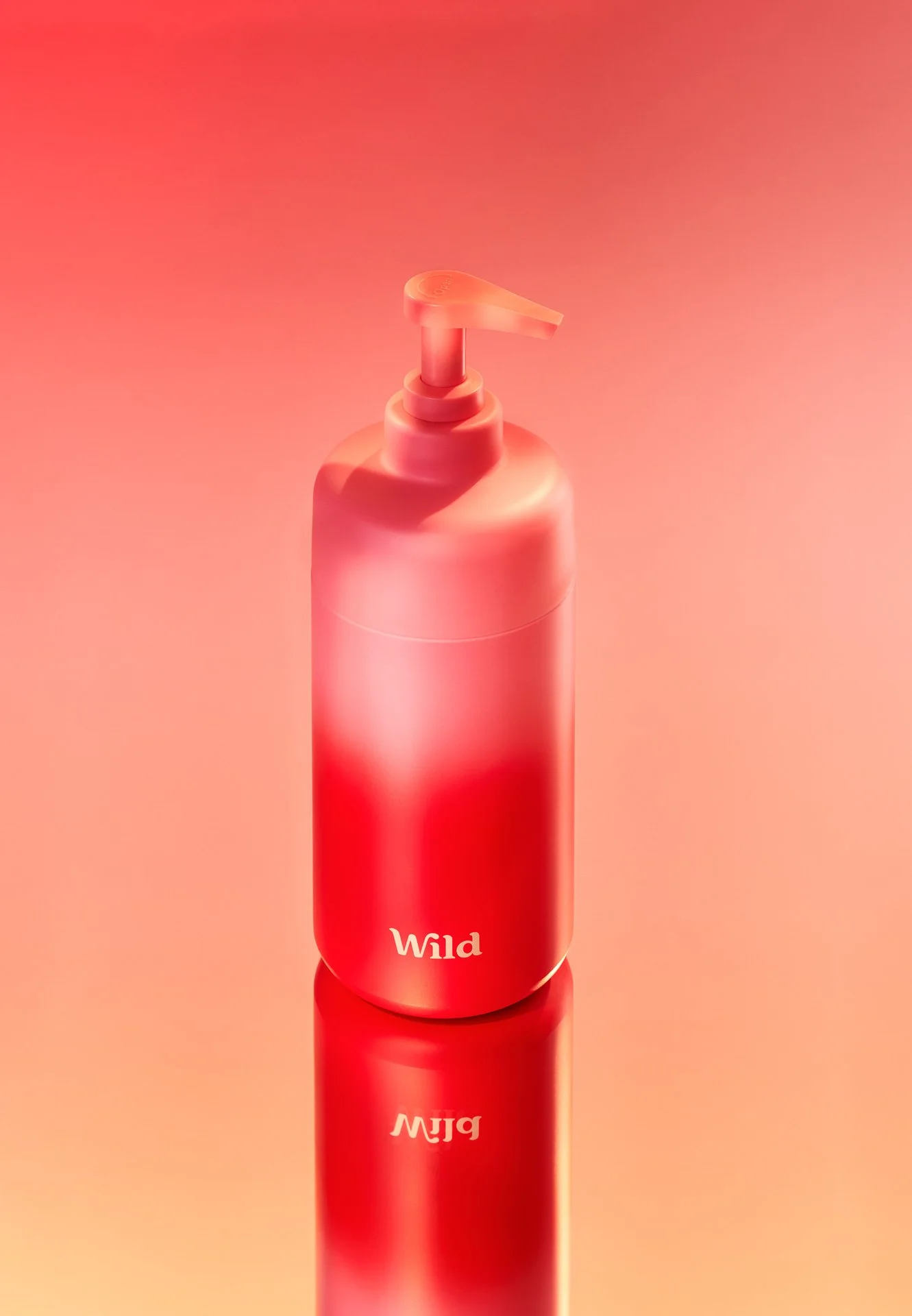 Red and pink ombre shower gel bottle, placed on a sunset backdrop, mimicking the bottle design.